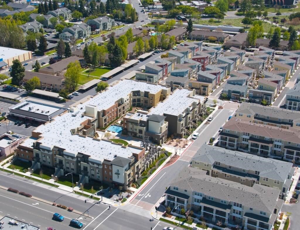 an aerial view of an urban neighbourhood with buildings with white roofs