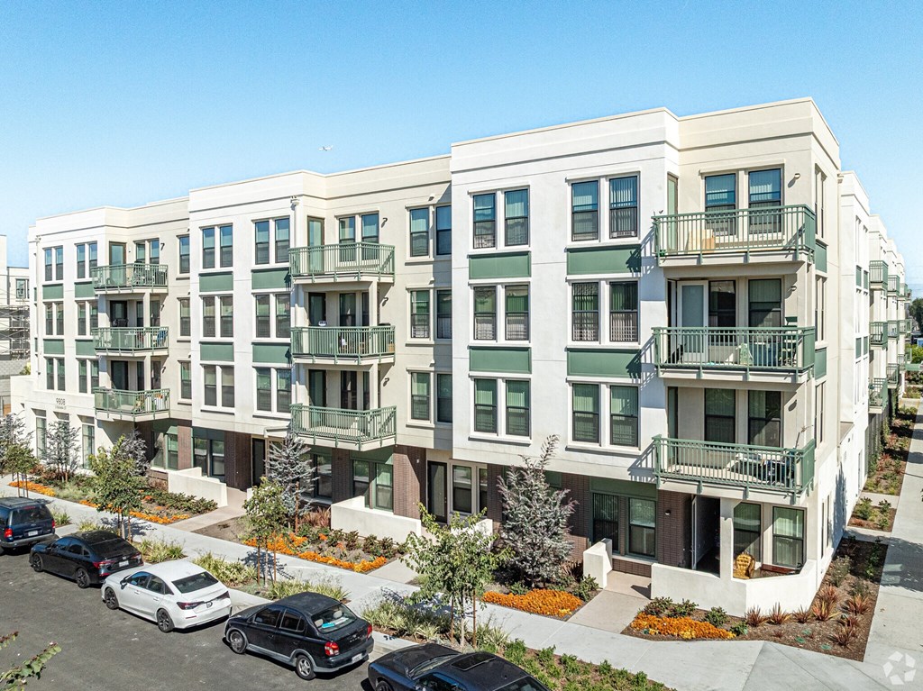 Apartment building with cars parked in front.