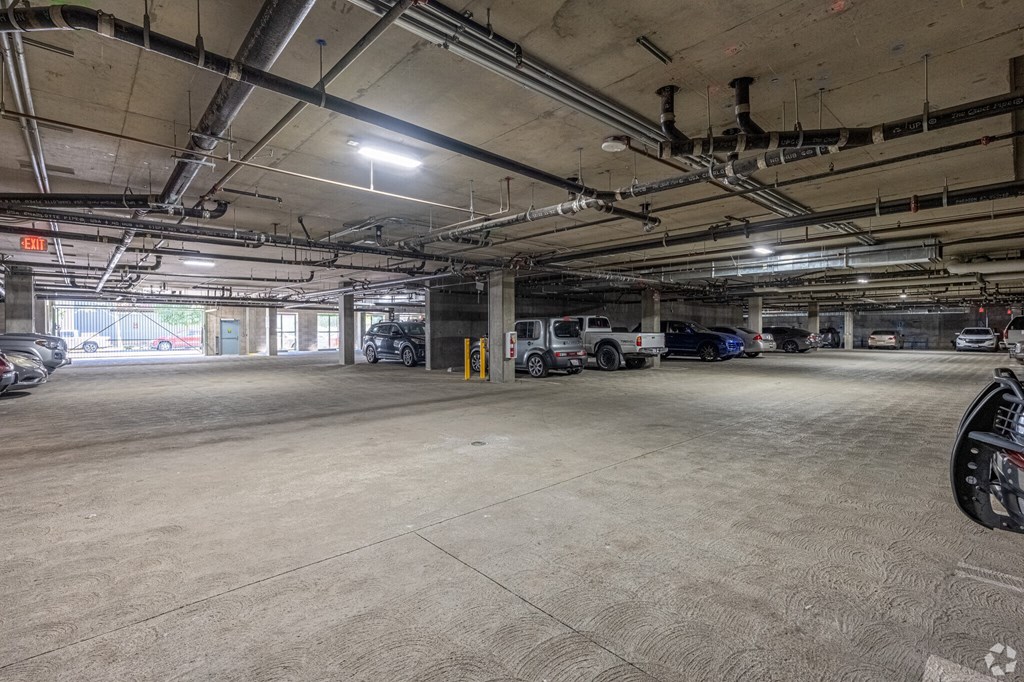 A spacious parking garage with multiple cars parked.