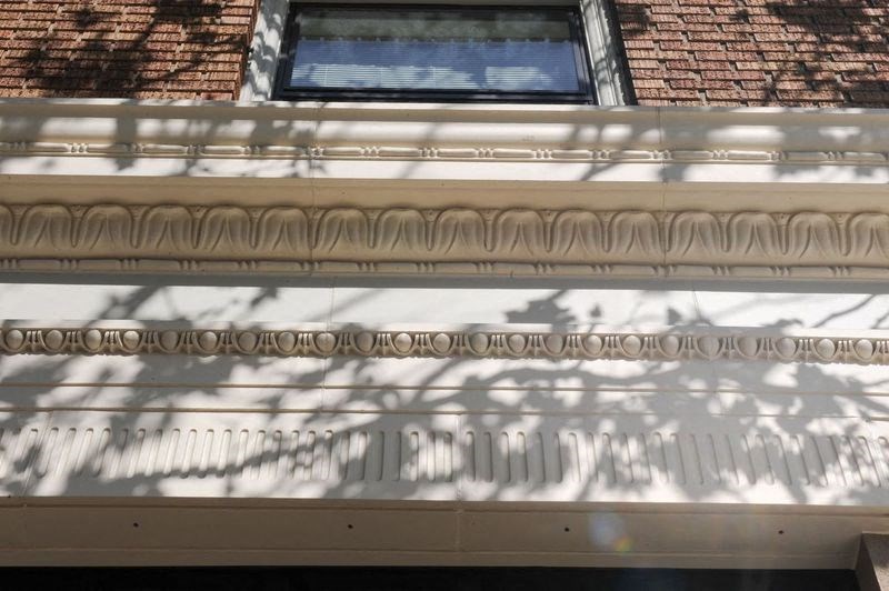 a building facade with a window and shadows on it