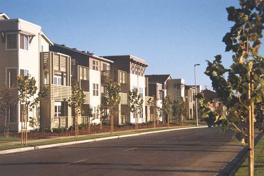 a row of apartment buildings on the side of a street