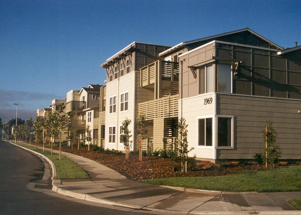 a row of apartment buildings on the side of a street