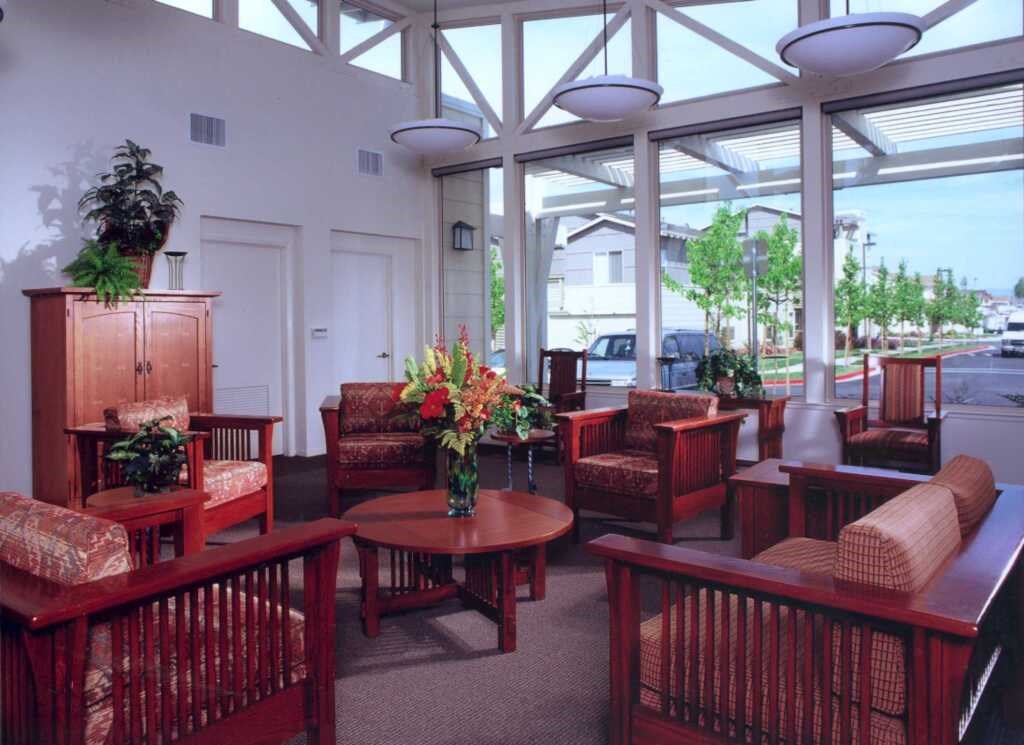 a lobby with chairs and tables and a large window