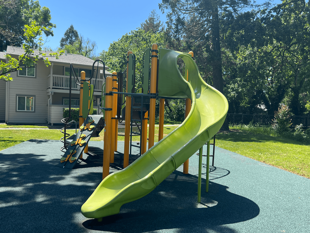 A bright yellow slide in a playground.