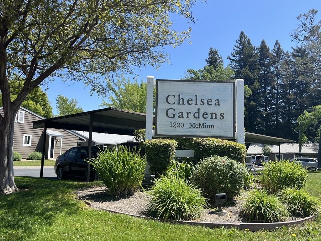 A sign for Chelsea Gardens stands in front of a building.