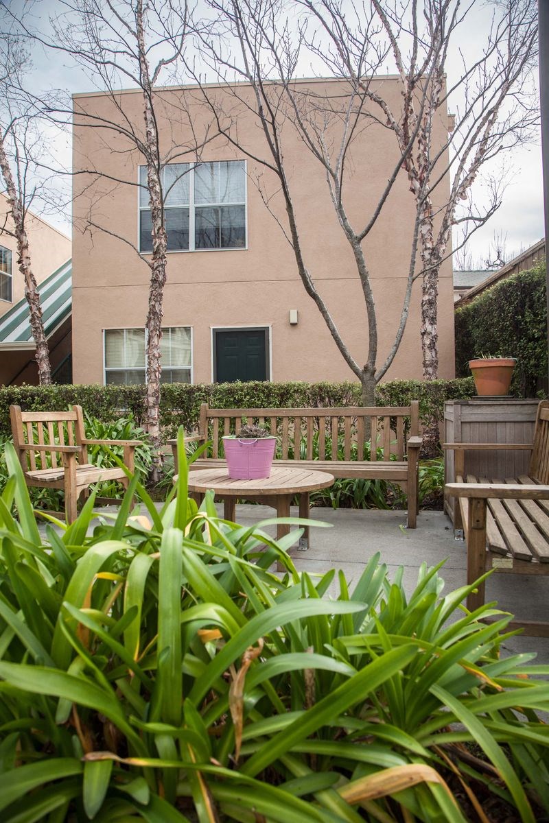 a patio with benches and a table in front of a building