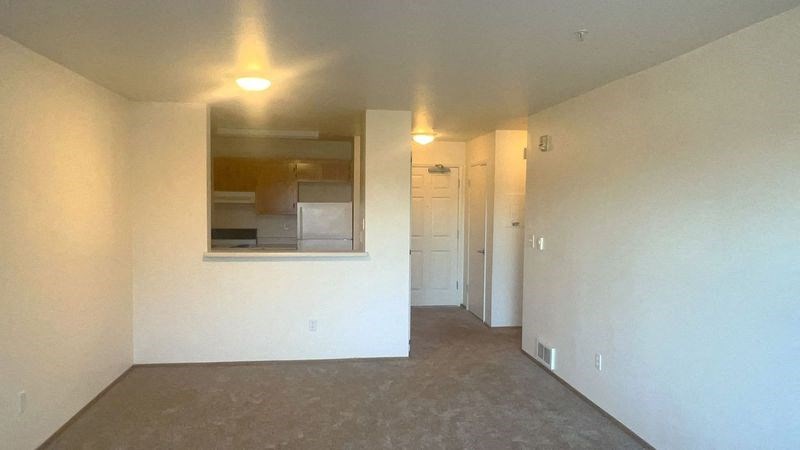 an empty living room with white walls and a window