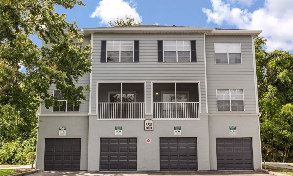 A grey two-story building with a balcony on the second floor.