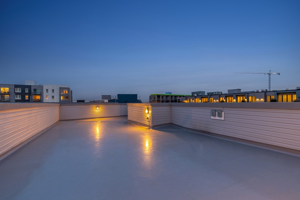 the roof terrace at night with the city in the background