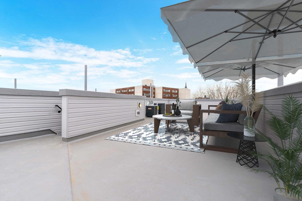 a patio with an umbrella and a table on a roof