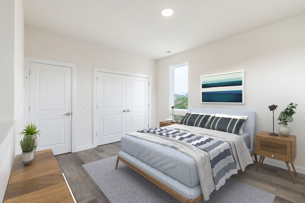 a bedroom with white walls and a bed with a blue and white blanket