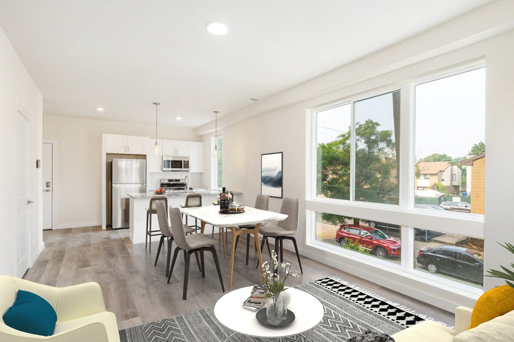 a living room with a table and chairs and a large window