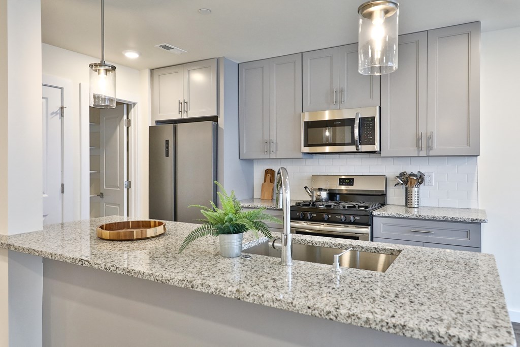 Kitchen a kitchen with grey cabinets and a granite counter top