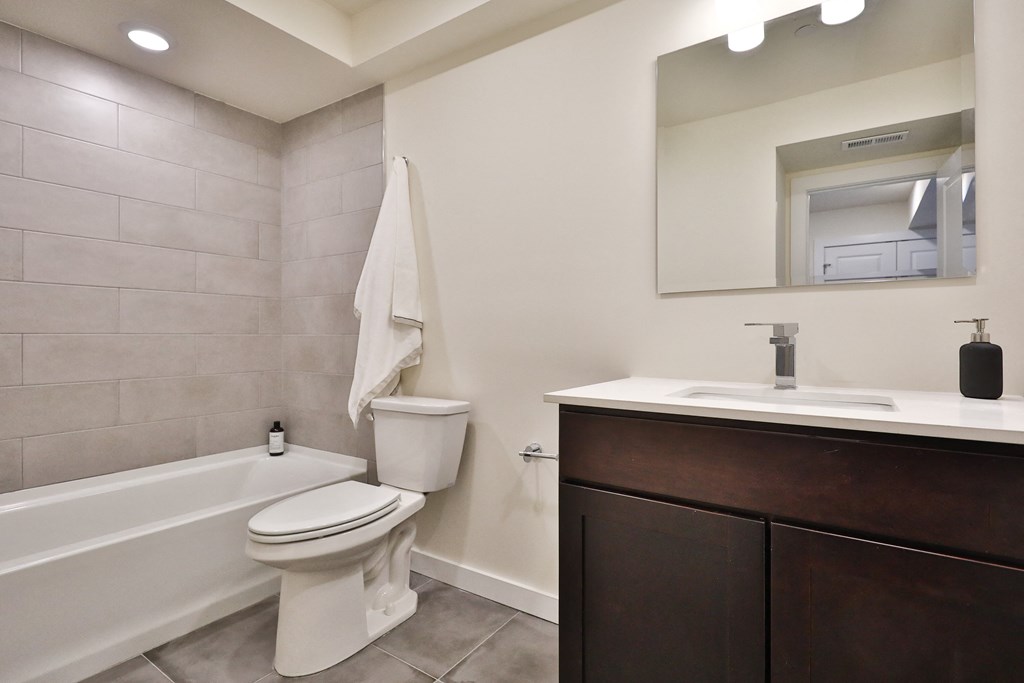 a bathroom with a toilet sink and tub and a mirror