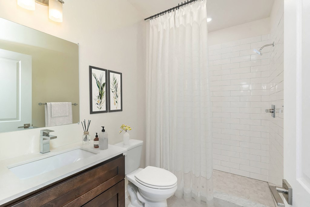 a bathroom with a shower and a sink and a toilet