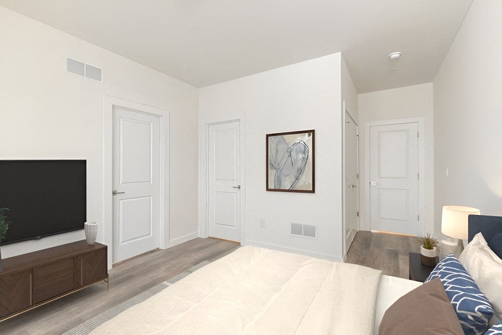 a bedroom with white walls and a couch and a tv