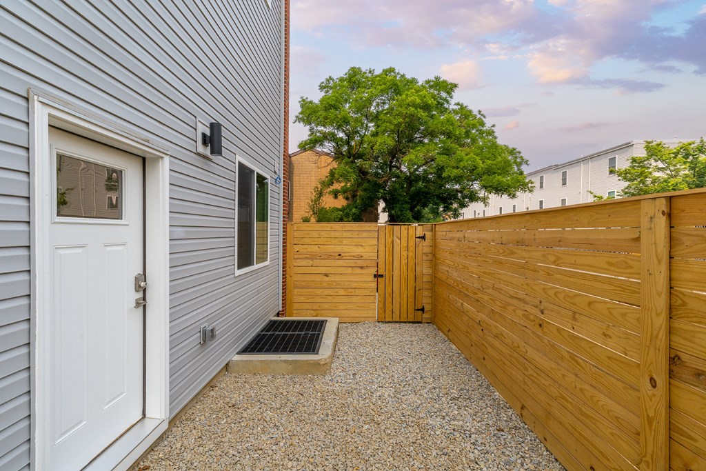 the side of a house with a wooden fence and a white door