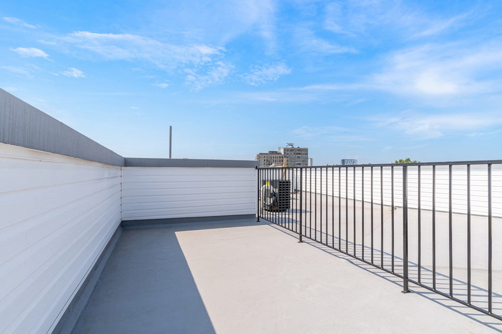 a balcony with a metal fence and a view of the city
