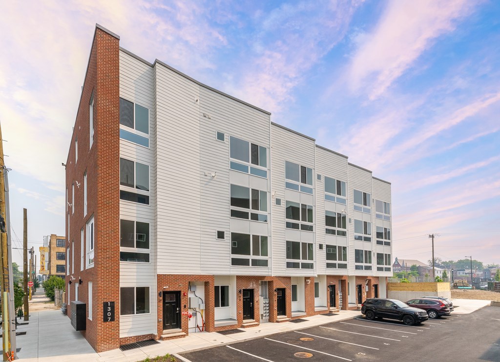 the exterior of a building with cars parked in front of it
