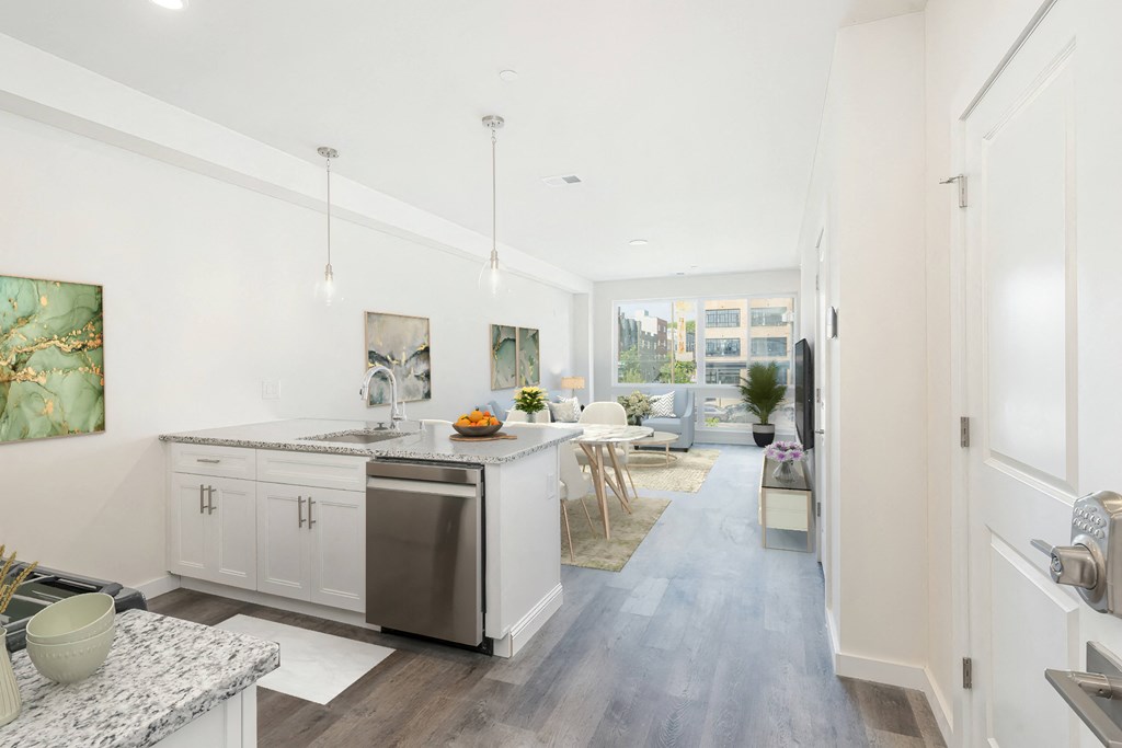 a kitchen and living room with white walls and white counter tops and a stainless steel