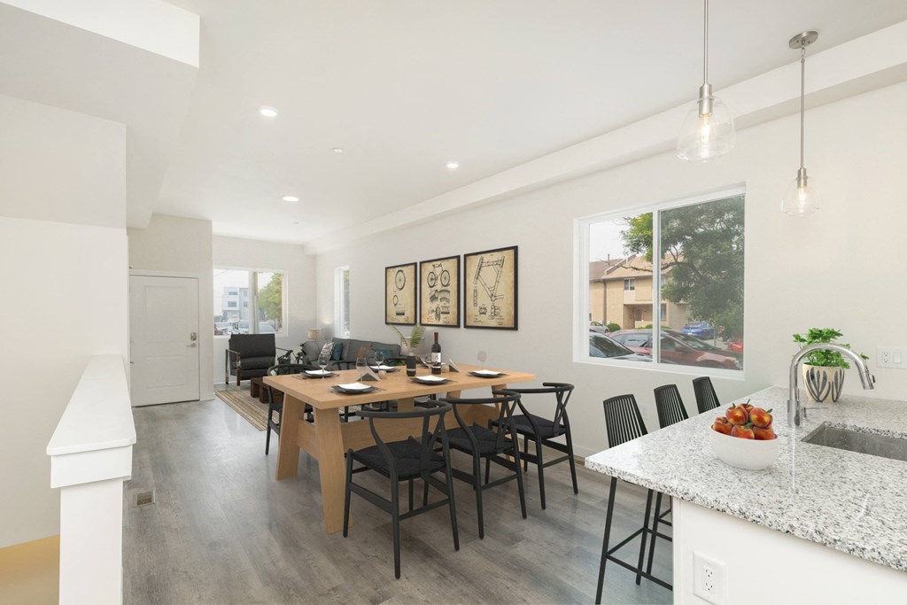 a dining area with a wooden table and chairs and a kitchen with a large window