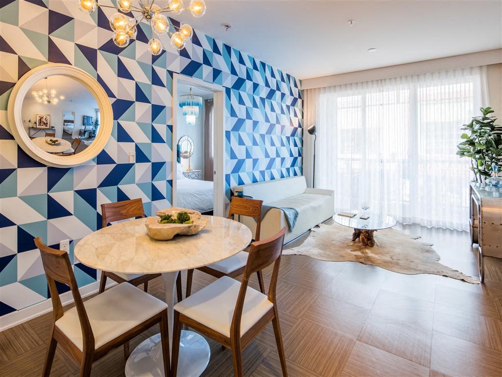 a living room with a table and a geometric wall