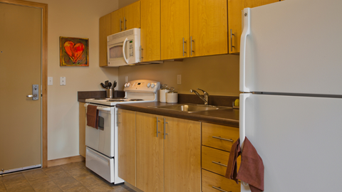 A kitchen with wooden cabinets and a white refrigerator.