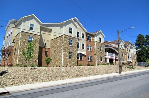 A large apartment building with a stone facade and multiple balconies.