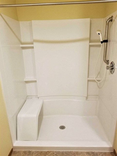 A white bathtub with a drain in the middle of it.