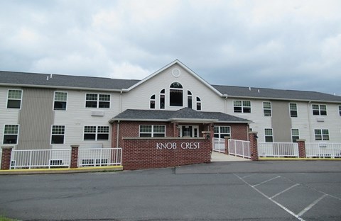 The front of a building with the name KNOB CREST on it.