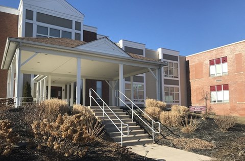 A building with a white porch and stairs leading up to it.