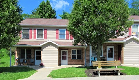 A house with a red door and a bench in front.
