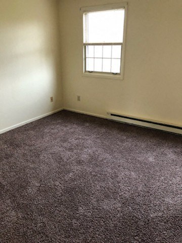 A room with a carpeted floor and a window.