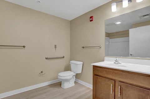 A bathroom with a toilet, sink, and mirror.