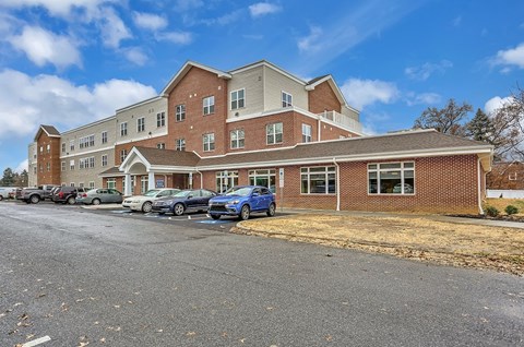 A large multi-story building with a parking lot in front.