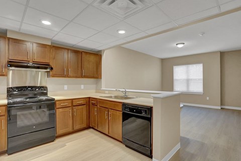 A kitchen with wooden cabinets and a black stove top oven.