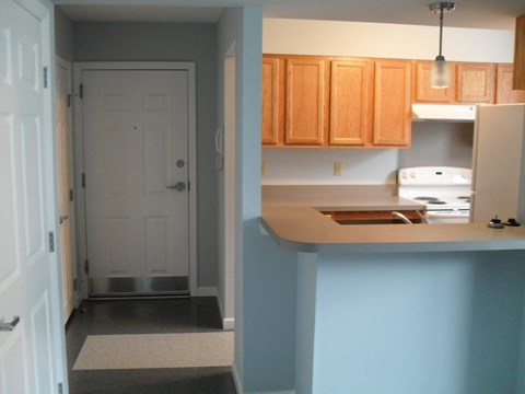 A kitchen with wooden cabinets and a white fridge.
