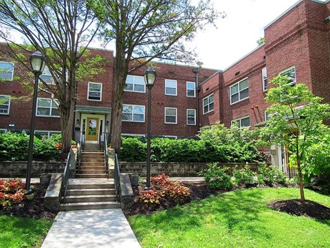 A red brick building with a tree in front of it.