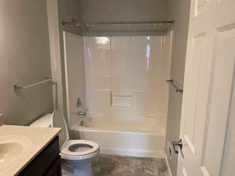 A white bathroom with a toilet, sink, and bathtub.