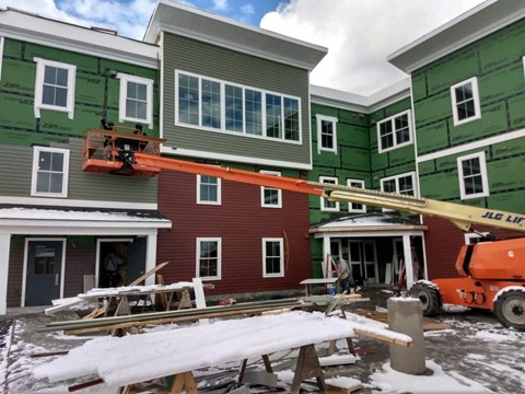 A red house is being painted green.