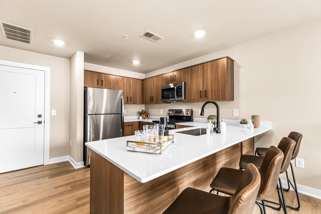 a kitchen with a large island with a sink and four chairs