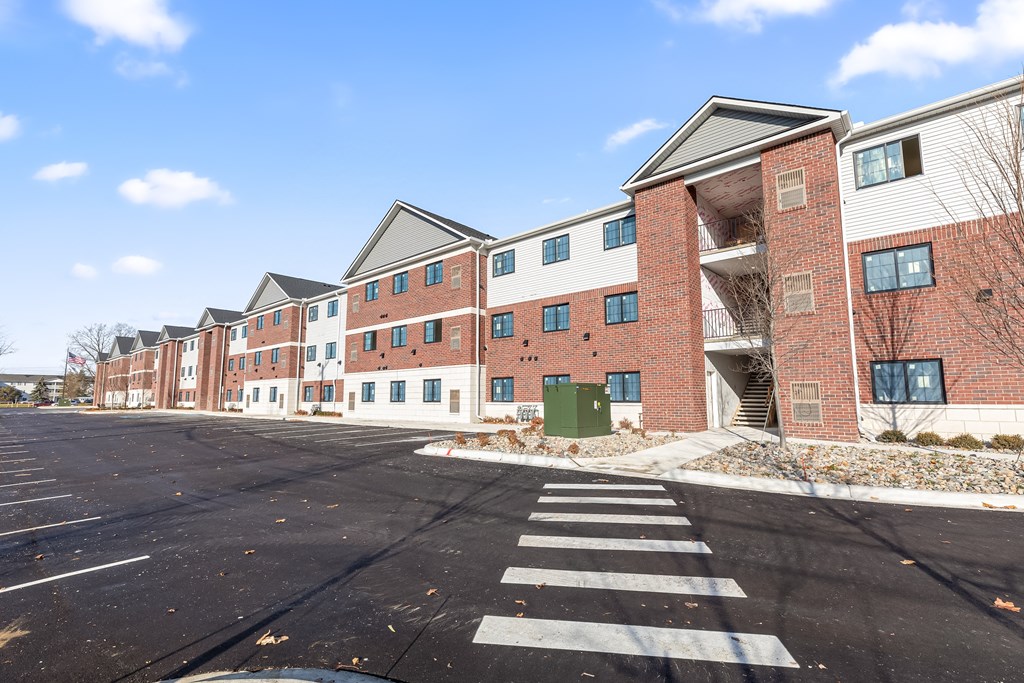 an empty street in front of a brick apartment building