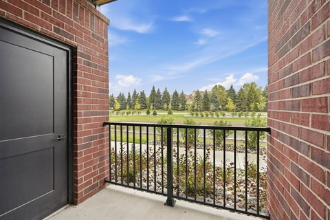 A black door is on the left of a brick wall.