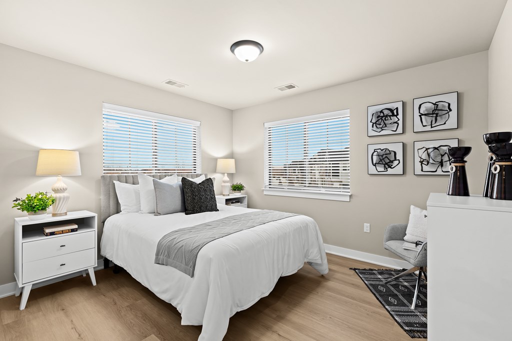 A bedroom with a bed, nightstand, and chair.