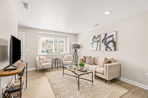 A living room with a couch, chairs, and a coffee table.