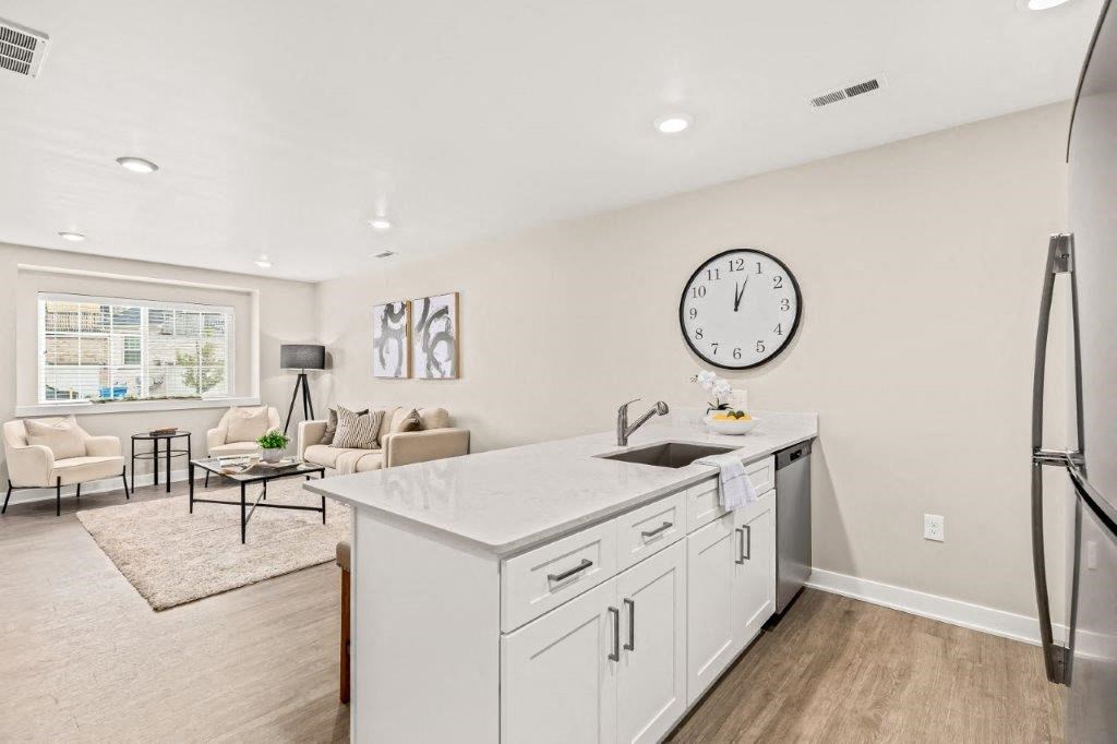 a white kitchen with a large clock on the wall
