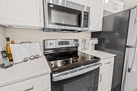 A modern kitchen with white cabinets and stainless steel appliances.