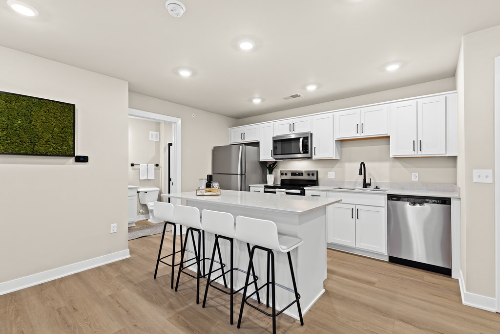 A kitchen with white cabinets and a large island.