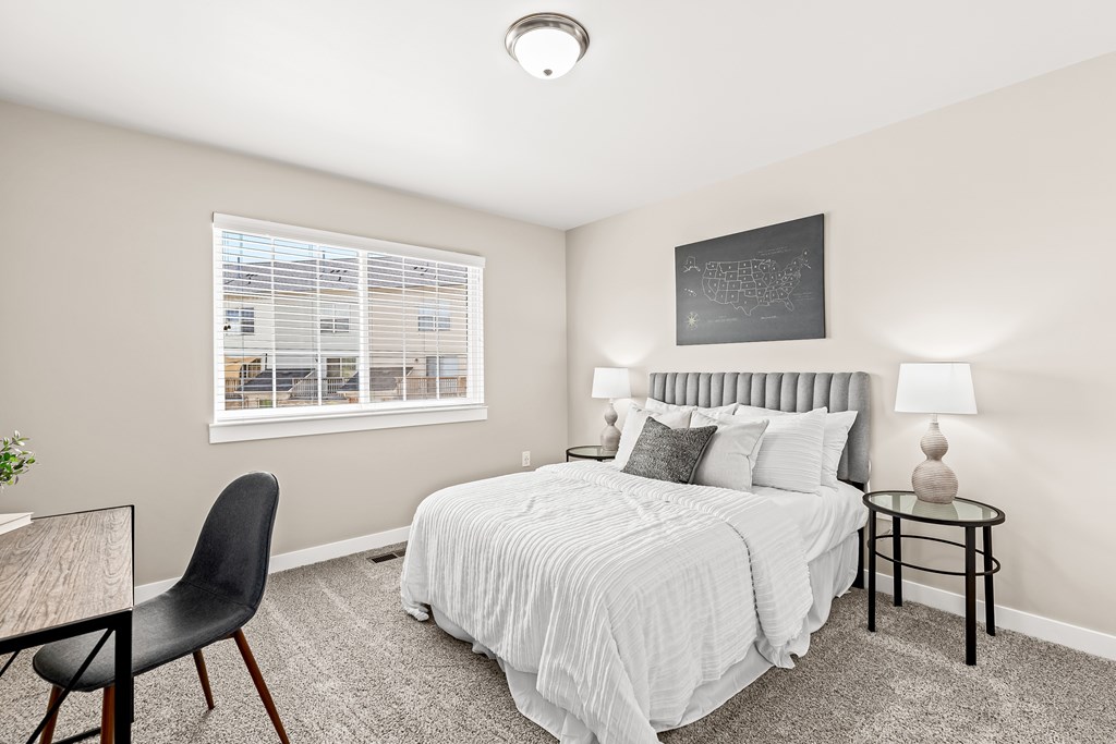 a bedroom with a bed and a desk with a chair