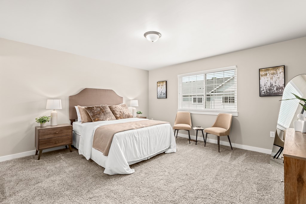 a bedroom with a bed and two chairs